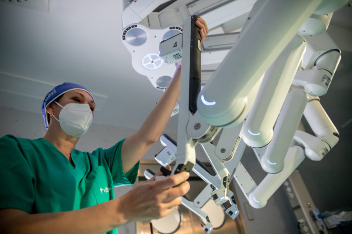 Personal de la Unidad de Cirugía Robótica preparando los brazos del robot Da Vinci para una cirugía