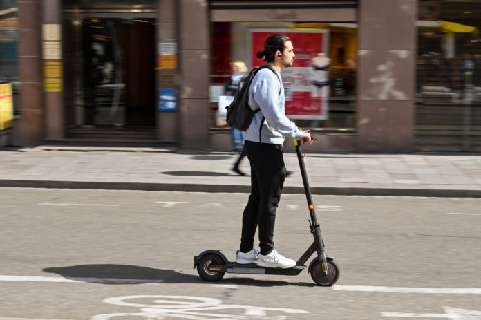 Person riding an electric scooter with blurred motion