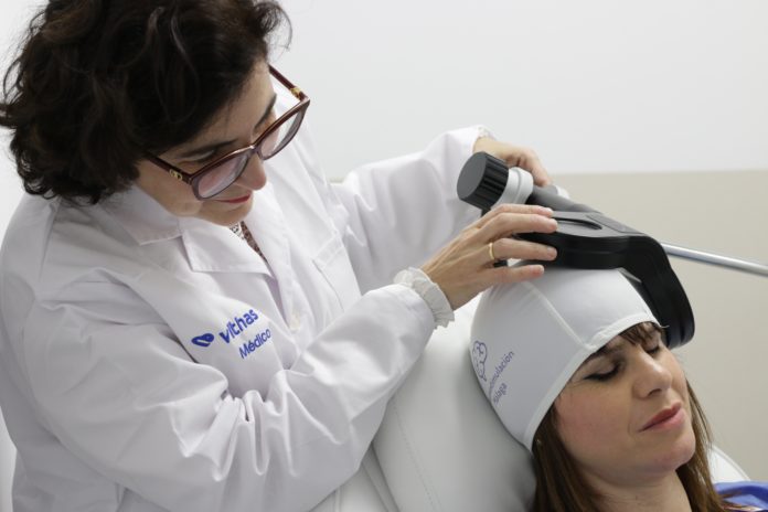 Dra. Victoria Fernández aplicando la neuroestimulación magnética